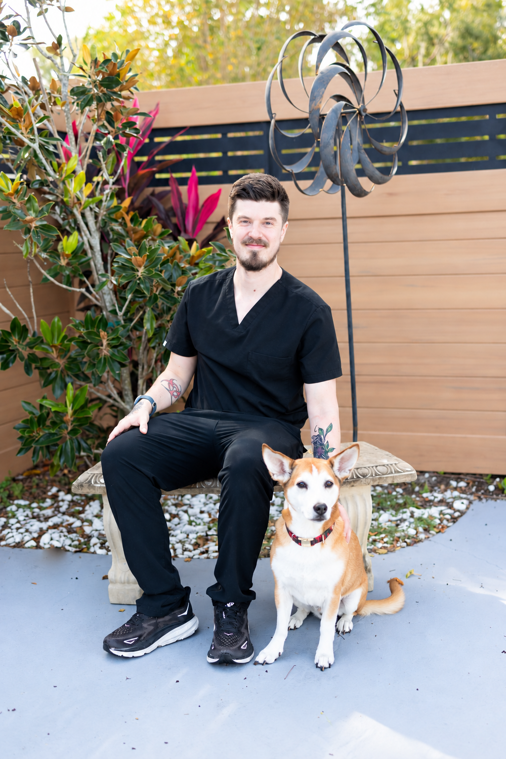 Eric, a veterinary technician, with his tan-and-white dog.